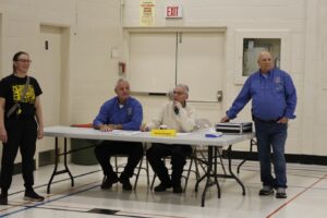 Knights Phil Crane, Bishop Robert Bourgon, Mike Maisonneuve, and Gym Teacher Rachell Russell at the scorekeeper table.